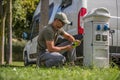 Men Attaching Electric Plug to RV Park Hookup Royalty Free Stock Photo