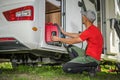Men Removing Portable Gas Generator From His Camper Van RV Storage Area Royalty Free Stock Photo