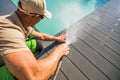 Men Washing His Swimming Pool Deck Using Garden Hose