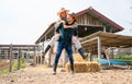 Caucasian man and woman farmer enjoy with woman riding on the back of man and go around the area of their farm with happiness and