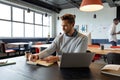 Caucasian mid adult businessman writing in diary by laptop in creative office Royalty Free Stock Photo