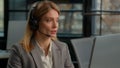 Caucasian middle-aged adult woman business female 30s businesswoman worker in office with headset using computer talking