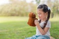 Caucasian mix girs play teddy bear doll at outdoors park, Picnic time
