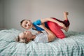 Caucasian mother and boy son playing in bedroom at home. Mom rocking child on her knees feet legs. Family having fun together. Royalty Free Stock Photo