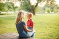 Caucasian mother and boy toddler son sitting together face to face and talking to each other Royalty Free Stock Photo