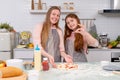 Caucasian mother with her daughter help to cook bakery together in kitchen and look happy with show to camera