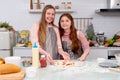 Caucasian mother with her daughter help to cook bakery together in kitchen and look happy with show to camera