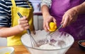 Caucasian mother scratching a lemon teaching her son to cook and preparing the ingredients to make a cake