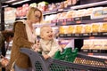 Caucasian mother shopping with her infant baby boy child choosing products in department of supermarket grocery store. Royalty Free Stock Photo