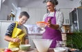 Caucasian mother teaching her son how to cook preparing the ingredients to make a cake