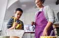 Caucasian mother teaching her son how to cook preparing the ingredients to make a cake