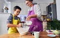 Caucasian mother teaching her son how to cook preparing the ingredients to make a cake