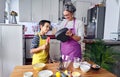 Caucasian mother teaching her son how to cook preparing the ingredients to make a cake