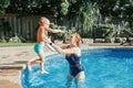 Caucasian mother training toddler son to swim in swimming pool outdoor. Baby boy diving jumping in water with goggles. Water Royalty Free Stock Photo