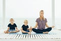 Caucasian mother with two sons practices yoga outdoor Royalty Free Stock Photo