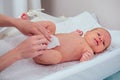 caucasian mother using wet wipes,applying baby powder before putting diapers on her four month old baby in bed at home Royalty Free Stock Photo