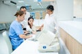 Caucasian nurse measure blood pressure of Asian woman and support by her family with husband, little girl and grandmother in area Royalty Free Stock Photo