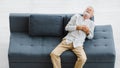 Caucasian old senior elderly gray hair and bearded man lying down close eyes on sofa in living room at home alone holding hands on Royalty Free Stock Photo