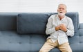 Caucasian old senior elderly gray hair and bearded man lying down close eyes on sofa in living room at home alone holding hands on Royalty Free Stock Photo