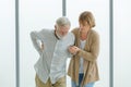 Caucasian old senior elderly supportive wife helping support holding hands of unhealthy sick grey bearded male husband walking Royalty Free Stock Photo