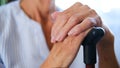 caucasian old senior grandmother holding walking cane stick in hands. old wrinkled hands of a grandmother with a cane