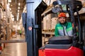 caucasian operator man working on Electric Forklift Truck in warehouse, dressed in uniform Royalty Free Stock Photo