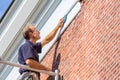 Caucasian painter cleans roof molding with cloth