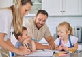 Caucasian parents helping children with homework. Happy siblings doing school work. Mother helping her son with homework Royalty Free Stock Photo