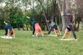 Caucasian people doing yoga in park outside on sunset