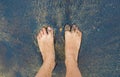 Caucasian person feet foot standing on black volcanic sandy beach Royalty Free Stock Photo