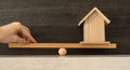 A person's hand balancing the heavy weight of maintaining a home.