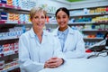 Caucasian pharmacist manager and mixed race female assistant smiling while standing in pharmacy Royalty Free Stock Photo