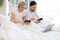 Caucasian playing video games while lying under blanket at home. Royalty Free Stock Photo