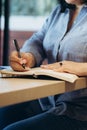 Caucasian Plus size woman making plan in notepad, writing, cropped photo.
