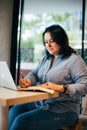 Caucasian Plus size woman making plan in notepad, writing, making notes