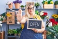 Caucasian plus size woman working at florist holding open sign with open hand doing stop sign with serious and confident