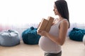 Caucasian pregnant woman with equipment holds pilates equipment in the hall with chair bags. Expectant mother with Royalty Free Stock Photo