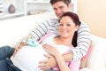 Caucasian pregnant woman holding baby shoes Royalty Free Stock Photo