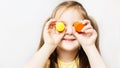 Caucasian preschool little girl holding gouache cans in her hands on white background