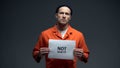 Caucasian prisoner holding Not guilty sign, asking for justice, human rights Royalty Free Stock Photo