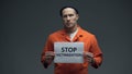 Caucasian prisoner holding Stop victimization sign violent treatment in jail