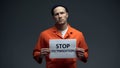 Caucasian prisoner holding Stop victimization sign violent treatment in jail Royalty Free Stock Photo