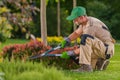 Caucasian Professional Garden Worker Trimming Plants
