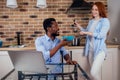 Caucasian redhaired ginger woman cooking traditional russian soup borscht to her african-american man in kitchen Royalty Free Stock Photo