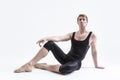 Caucasian Relaxed Ballerino Dancer Sitting While Practising Stretching Exercices Before Training In Black Sportive Tights in