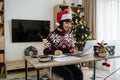 Caucasian remote employee starting day at home decorated with Christmas tree