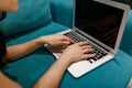 Caucasian remote worker working on the portable computer while resting on the comfortable fabric sofa at home. Online