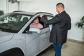 Caucasian salesman holding clipboard and talking about buying car with sale with his customer Royalty Free Stock Photo