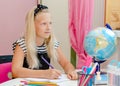 Caucasian school kid looking at the window while studying. Learning at home concept