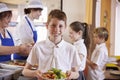 Caucasian schoolboy holds plate of food in school cafeteria Royalty Free Stock Photo